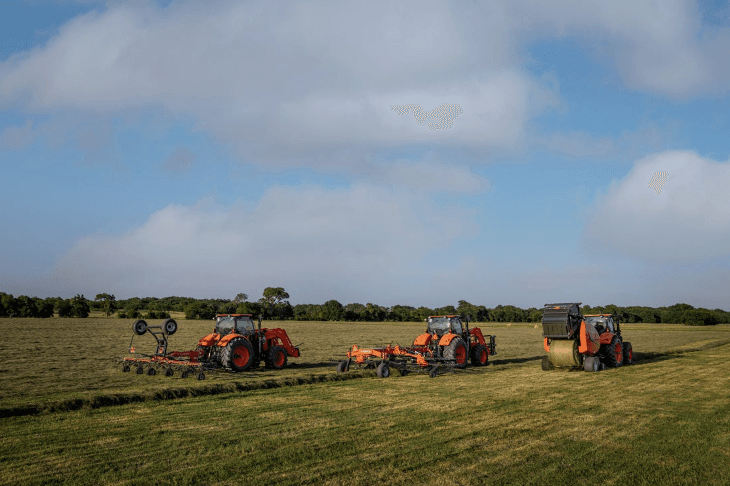 Fleet of tractors creating hay bales