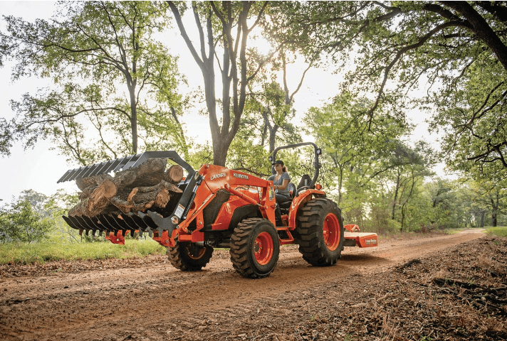 Woman operating tractor with front grapple