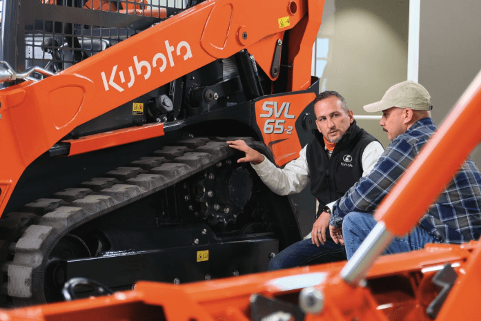 Kubota employee showing a track loader model to customer